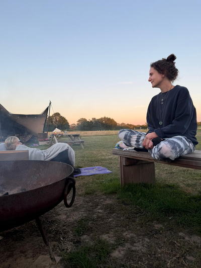 Caz sitting cross-legged at sunset, leading a guided meditation